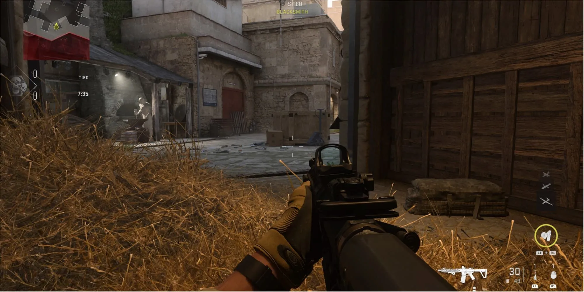 Một game thủ ẩn mình trong đống cỏ khô tại chuồng ngựa trong Call of Duty: Modern Warfare 2, thể hiện hành vi camping
